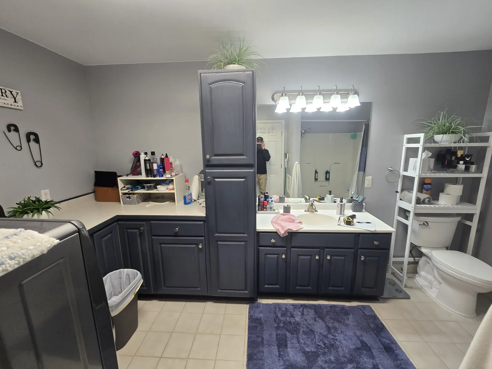 The finished Novi bathroom and laundry with navy vanities and a patterned floor