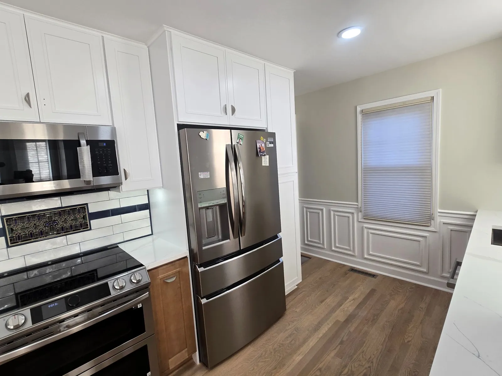 The finished Plymouth kitchen: two-tone cabinets, quartz counters and subway backsplash