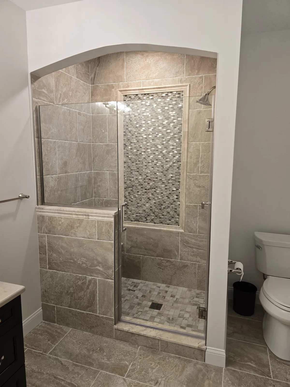 The finished West Bloomfield custom shower: arched tiled opening, bench and mosaic accent